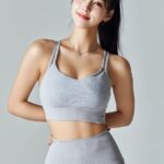 a korean woman in her 20s with a ponytail stands in a relaxed, upright pose in a...