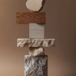 A conceptual stack of stone building bricks, concrete and timber. It is set agai...
