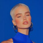 Dark moody luxury 85 mm full body portrait of a nordic personal trainer with tre...