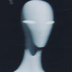 A blurry, out-of-focus photo shows an alien in the dark. Against the black backg...