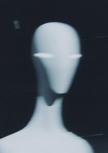 A blurry, out-of-focus photo shows an alien in the dark. Against the black backg...