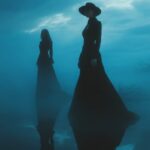 A dark cinematic shot of two figures...