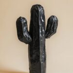 A cactus made of black plastic bags, simple background, minimalist art collage, ...