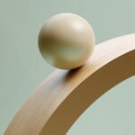 A light beige sphere rolling on the edge of an abstract golden arch, a giant pas...