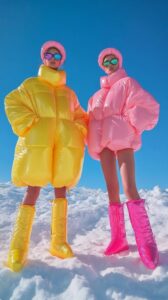 Two beautiful fashion models full body wide shot, wearing glasses, dressed in ov...