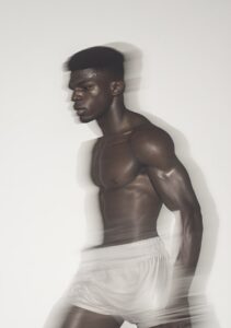 low res CCTV footage grab of a African American boxer shadow boxing on a white b...