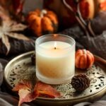 A beautifully crafted candle placed on an elegant tray, surrounded by autumnal d...