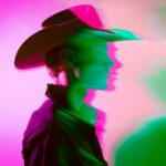 Editorial fashion photography, profile of a Man with cowboy hat, vivid motion bl...
