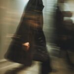 a blurry photo of a caucasian male top-model walking on mirror-catwalk at balenc...