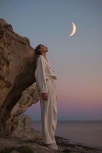 an editorial photo an androgynous male, moon, island, sunrise, celestial mystici...