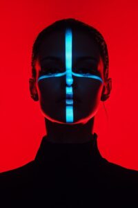 Red background, woman silhouette with her face lit by blue omni effect lighting ...