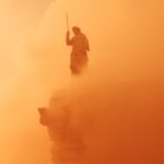close up detail shot ,tiny greek Statue on a top of giant column, Orange Heat Ha...