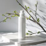Product photography, white makeup bottle on board, close-up, there is a branch w...