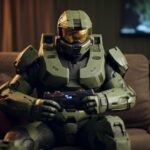Photo realistic, cinematic style shot of Master Chief from Halo sitting on a cou...