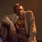 model wearing victoria beckham tailored pants with oversized grandpa cardigan wi...