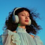 Female model wearing wireless headphones, light indigo and light gray style, ric...