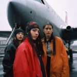 prompta airplane with three people standing in...