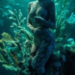 beautiful old stone sculpture of a woman overgrown by bioluminescent corals, Pho...