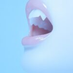 magazine photograpy of beauty cosmetics vampire, show fangs and mouth open, clos...