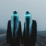 two people in black suits, one with long white hair and futuristic mask on face ...