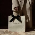 Prompta photo of an elegant woman holding and showcasing the "your brand" brand ...