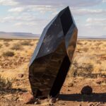 a long black contemporary art sculpture like an abstract dichroic voronoi shaped...