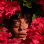 Epic scene, magazine cover featuring a woman surrounded by pink chrome flowers. ...