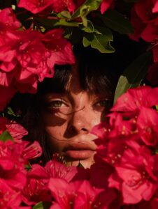 Epic scene, magazine cover featuring a woman surrounded by pink chrome flowers. ...