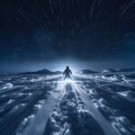 A snowmobile raced across the snowy landscape, leaving behind a trail of fresh p...