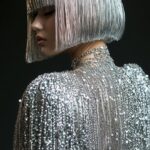 a beautiful model with a silver bob hairstyle made of beads and chains, wearing ...
