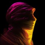 person in yellow, amber, magenta light on dark objects and black background, lig...