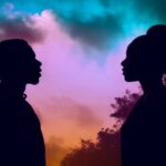 A silhouette of an african american male and female standing back to back lookin...