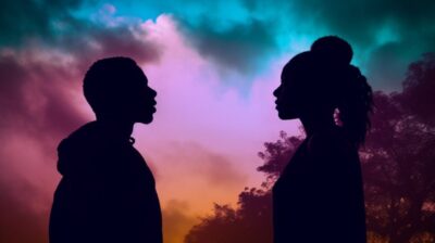 A silhouette of an african american male and female standing back to back lookin...
