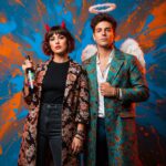 6 months ago

            A photo of a real man and woman standing side-by-side. Behind them is a wall with an abstract mix of blue and orange splashes. The wall has a shape that resembles devil's horns positioned behind the woman's head, giving the illusion that she has horns. The wall also has a shape resembling a halo positioned behind the man's head, giving the illusion that he has a halo. The woman has short, wavy dark hair and is wearing a black top, high-waisted dark pants, and a long, floral-patterned coat. She's holding a bottle with a colorful label. The man has tousled dark hair and is wearing a teal and orange patterned coat over a white shirt and dark pants. Both have medium skin tones and are adorned with various accessories, including bracelets and earrings. The image should be dynamic and expressive, with a focus on bold colors and intricate details.

          
            
                


    
          

  


    

      
        The_Promptonaut






    

  


            

            
                 10
 310