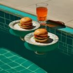 Two blue and white plates with burgers sitting on them, in the style of en plein...