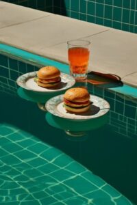 Two blue and white plates with burgers sitting on them, in the style of en plein...