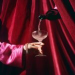 Prompt:editorial photograph of a hand wearing diamond jewelry and bright pink sa...
