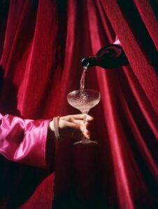 Prompt:editorial photograph of a hand wearing diamond jewelry and bright pink sa...